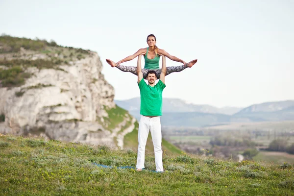 Acroyoga. kadın ve erkek dağda yoga yaparken — Stok fotoğraf