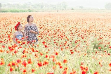 Anne ve kızı bir haşhaş alanına yürüyor. Yaz ruh hali