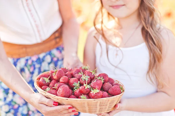 Mano de niño pequeño con cesta de fresa. Humor de verano — Foto de Stock