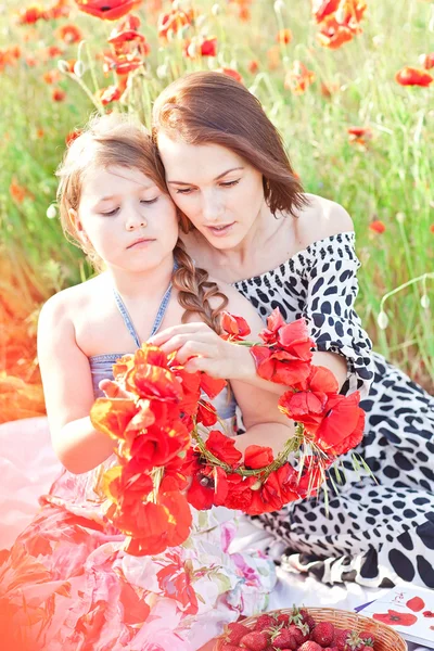 Anne ve dauhter yapar haşhaş çiçek çelenk üzerinde piknik — Stok fotoğraf