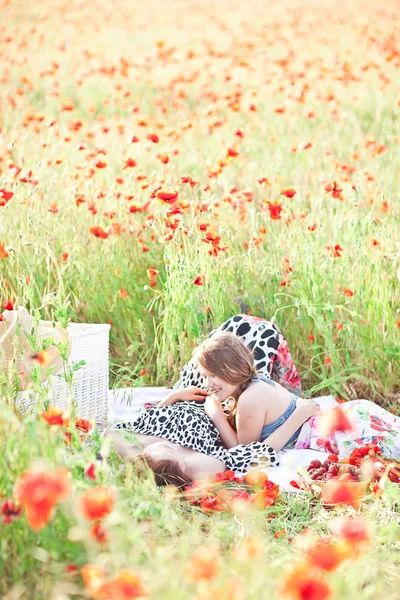 Mutter und Tochter liegen auf der weißen Decke und essen Erdbeere — Stockfoto