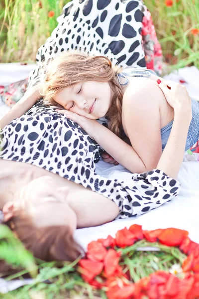 Matka a dauhter, ležící na bílou deku a jíst strawbe — Stock fotografie