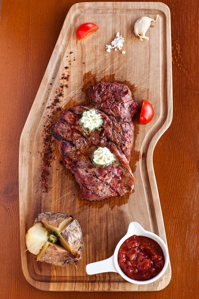 Club Beef steak with pepper sauce and Grilled vegetables on cutting board on dark wooden background — Stock Photo, Image