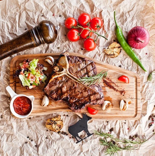 Club Beef stek z sosem pieprzowym i grillowane warzywa na desce do krojenia na ciemnym drewnianym tle — Zdjęcie stockowe