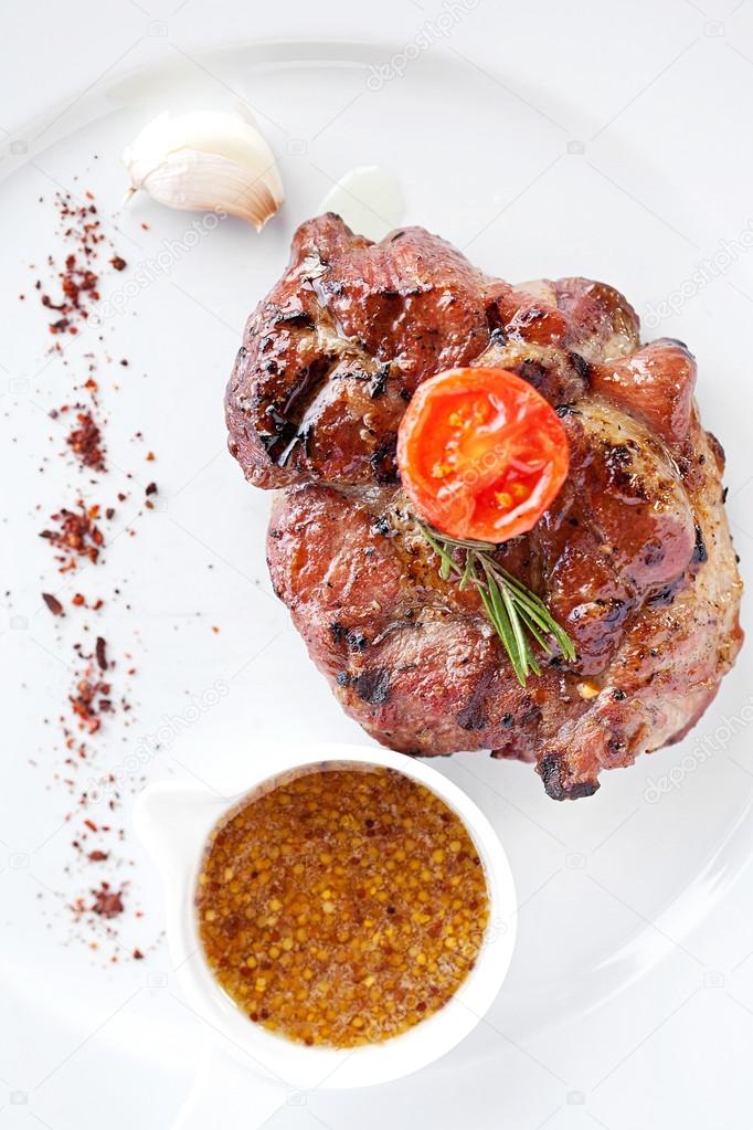 Club pork steak with pepper sauce and Grilled vegetables on white plate