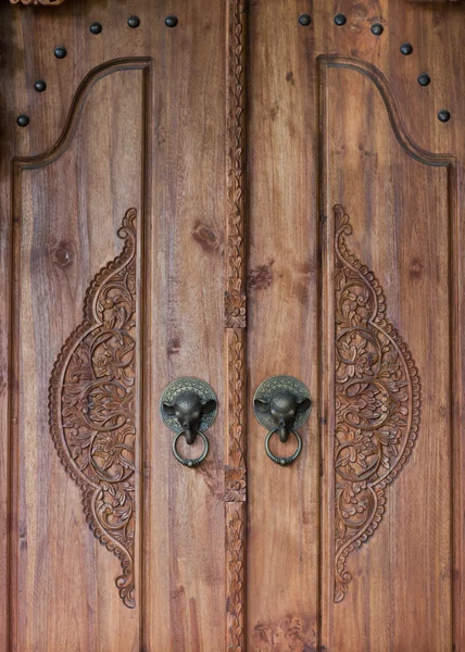 Puerta de madera vieja con mango de elefante de bronce. Tallar madera balinesa —  Fotos de Stock