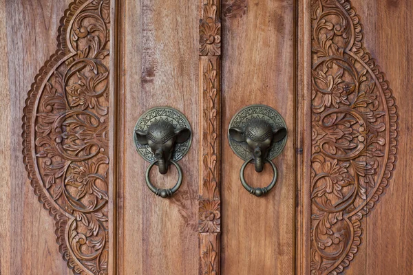ブロンズ象のハンドルを持つ古い木製のドア。木製バリを彫刻 — ストック写真