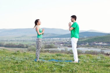 Acroyoga - Dengeleme ayakları üzerinde. Acroyoga Dağları'nda güneş doğarken pratik bir çift. Crimea