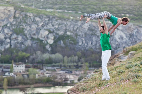 Acroyoga - Balancing on Feet. Couple practicing acroyoga in mountains at sunrise. — Stock Photo, Image