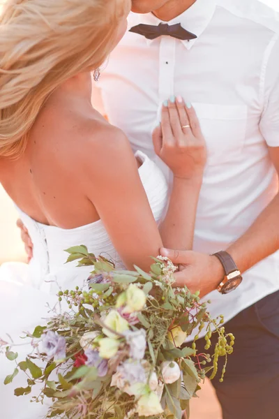 Elegante hermosa novia y novio caminando en la puesta de sol en el backgraund — Foto de Stock