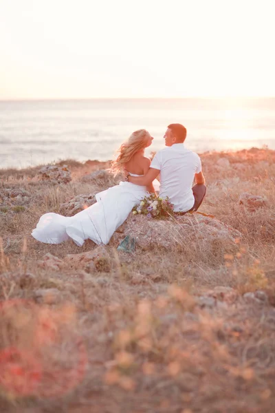 Elegant gorgeous bride and groom walking in sunset on the backgraund — Stock Photo, Image