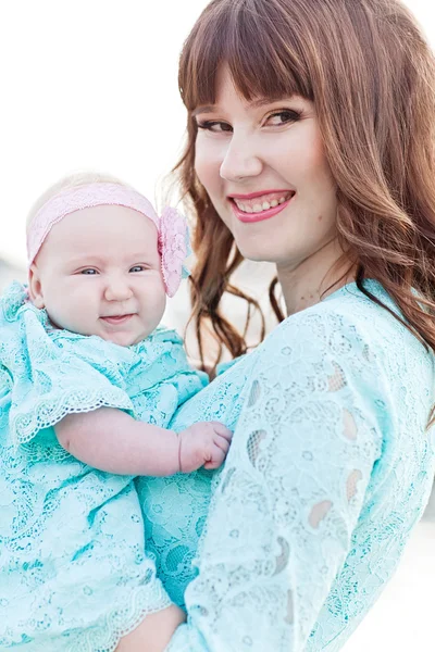 Portret van plezier liefdevolle moeder in blauwe jurk en haar baby overtreffen — Stockfoto