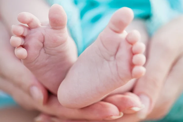 Pieds de bébé dans les mains de la mère — Photo