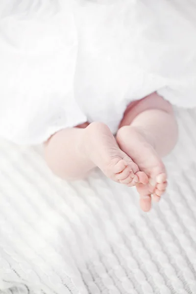 Pequeña niña recién nacida pies de bebé en bonito dr algodón blanco —  Fotos de Stock