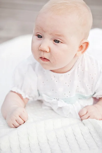 Baby Baby liegt glücklich lächelnd auf Strickdecke auf weißem Hintergrund — Stockfoto