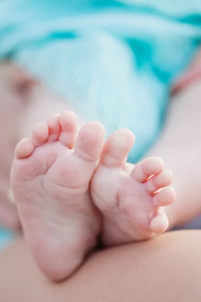 Pieds de bébé dans les mains de la mère — Photo