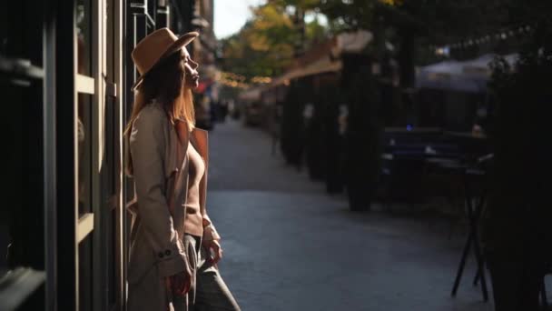 Młoda piękna kobieta turysta stoi na ulicy w słońcu — Wideo stockowe