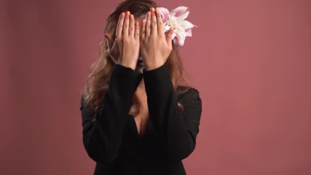 Portrait of a young woman with makeup for Halloween on a pink background. covers his face with his palms and puts his hands down — Stock Video