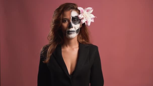 Porträt einer jungen Frau mit Make-up für Halloween auf rosa Hintergrund. Luftkuss — Stockvideo