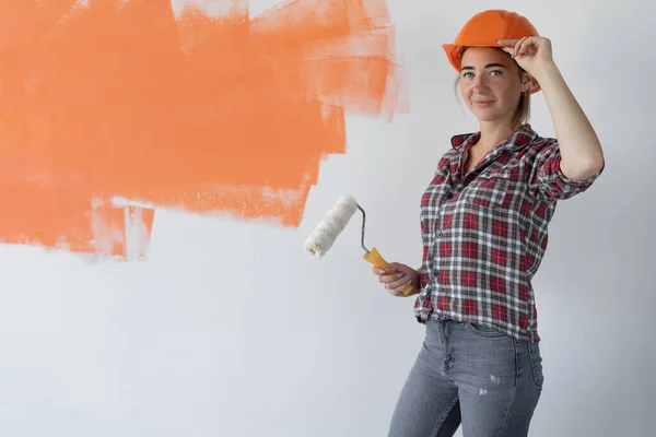 Szczęśliwa kobieta maluje ścianę w domu. Koncepcja renowacji — Zdjęcie stockowe