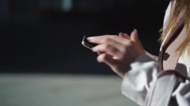 Yakın plan kadın parmak izleri. Sokakta akıllı telefon. Mesaj gönderiyor, notlar yazıyor.