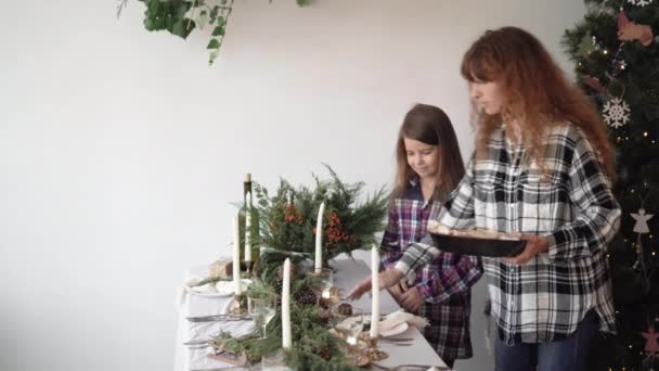 Ibu dan putrinya sedang mempersiapkan makan malam untuk Natal. membawa kue dan meletakkannya di atas meja — Stok Video
