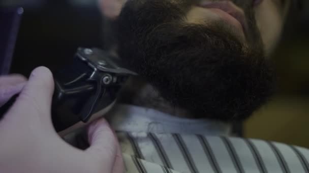 Primer plano de una barba mans, un trimer elimina el exceso de cabello — Vídeo de stock