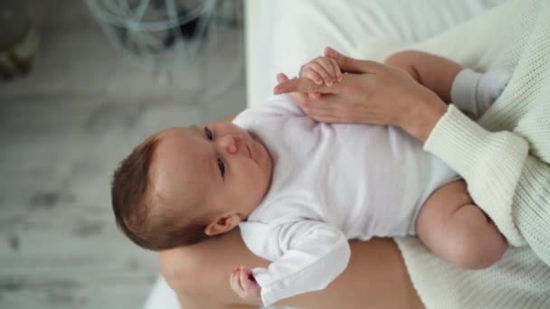 Kis újszülött csecsemő anyák lábán. Az ujját a kezében tartja. — Stock videók