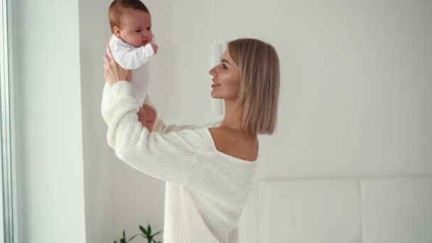 Szerető érzékeny kaukázusi fiatal anya gazdaság imádnivaló aranyos baba lány ölelés csók kisgyermek. — Stock videók
