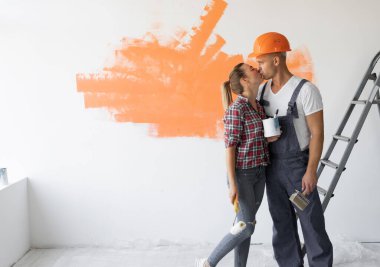 Adam tulum giymiş ve koruyucu bir kask giyip kızı öpüyor..