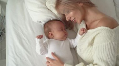 Bir anne ve yeni doğmuş bebeğinin en iyi görüntüsü, yatakta yatar. Mutlu annelik kavramı