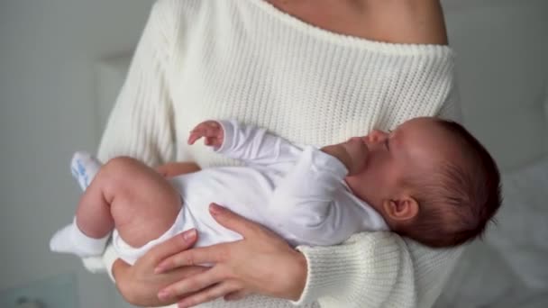Egy újszülött az anya karjaiban, különböző irányokba lendülve. Boldog gyerekek koncepciója — Stock videók