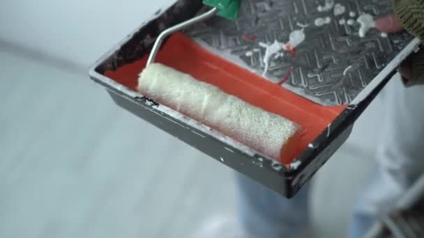 Gros plan du rouleau de peinture propre trempé dans de la peinture orange — Video