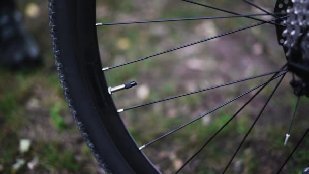 Close-up of cap on a bicycle, male hands remove the cap from the tire — Stok Video