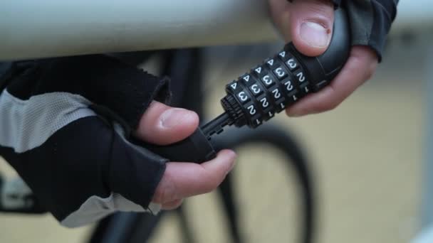 Primo piano di una serratura a combinazione per una bicicletta. Le mani maschili lo chiudono e mescolano i numeri — Video Stock