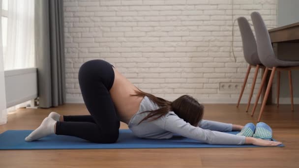 Biała kobieta w ciąży ćwiczy na tylnej macie. Zbocza i ugięcia. Rozciąganie się dla kobiet spodziewających się dziecka — Wideo stockowe