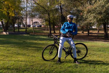 Parktaki bisikletçi dinlenmek için durdu. Önüne bakıyor..