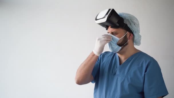 Médico que trabaja en un consultorio hospitalario utilizando tecnología de realidad virtual. usando una máscara médica usando gafas vr — Vídeos de Stock