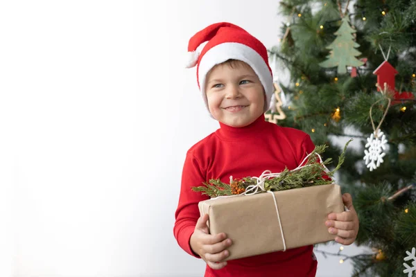 Ein Fröhlicher Kleiner Junge Steht Neben Einem Weihnachtsbaum Und Hält — Stockfoto