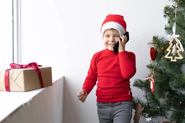 Kaukasischer Junge Mit Rotem Weihnachtsmann Hut Steht Fenster Und Telefoniert — Stockfoto