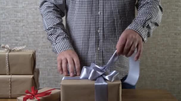 Male hands untie a big beautiful bow on the box. Gift open concept. — Stock Video