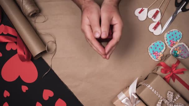 Top vista mãos masculinas colocar uma pequena caixa vermelha sobre a mesa. conceito dia dos namorados. — Vídeo de Stock