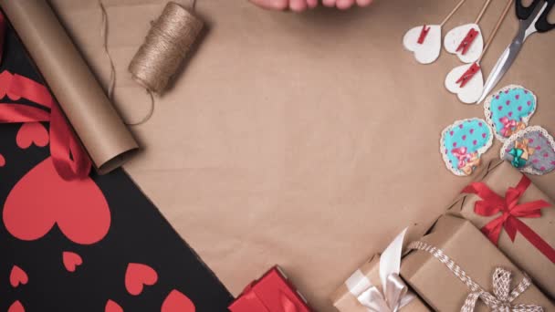 Mužské ruce složené k sobě ležely na stole velké červené papírové srdce. Koncept na oslavu Valentýna. — Stock video