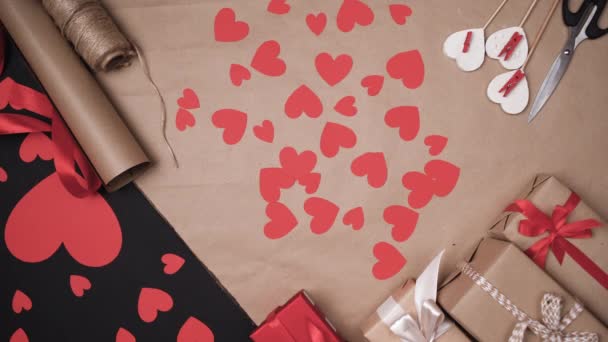 Podstavec z papírových srdcí, mužské ruce položily malou červenou krabičku. Koncept na oslavu Valentýna. — Stock video
