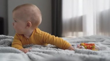 Avrupalı görünümlü bir çocuk yerde yatıyor ve gülümsüyor. Tasasız çocukluk konsepti