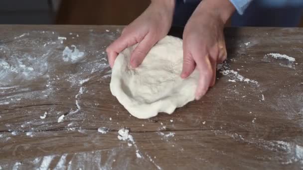 Dziecięcych dłoni na stole przygotowujących skórkę surowego ciasta pizzowego. — Wideo stockowe