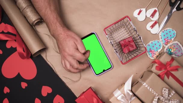 Of shopping basket and phone with green screen. Male hands are shopping online. — Αρχείο Βίντεο