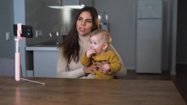 Anne ve küçük oğlu evde, mutfakta, ailede, ev güvenliğinde, babalıkta, teknoloji konseptinde selfie ya da video araması yapıyorlar..