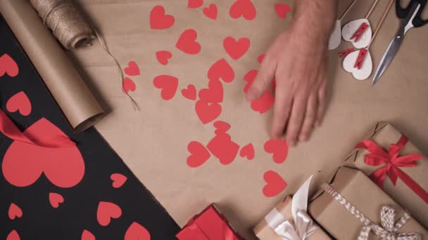 Mans mains retirent les coeurs de papier de la table. Valentines concept de fin de vacances. — Video