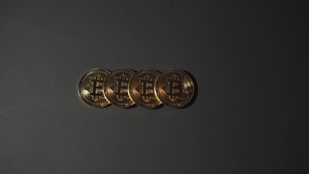Cztery bitcoiny na czarnym tle, męskie ręce zbierające je jeden po drugim. Koncepcja zakupu i sprzedaży kryptowaluta. — Wideo stockowe